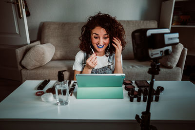 Young woman using tablet while sitting on table