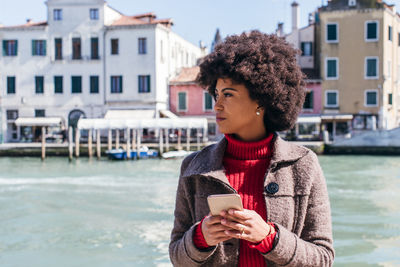 Full length of man using mobile phone in water
