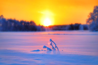 Scenic view of frozen lake against sky during sunset