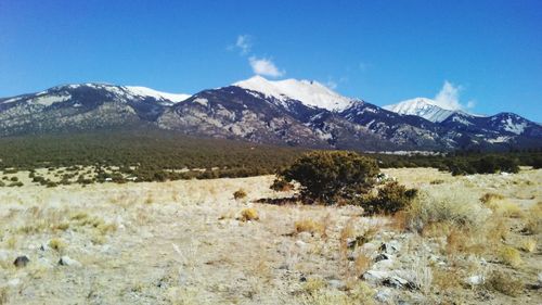 Scenic view of snowcapped mountains against blue sky