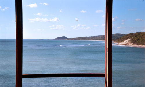 Scenic view of sea against sky seen through window