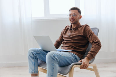 Businessman with laptop sitting on chair