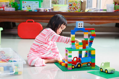 Boy playing with toy sitting on table