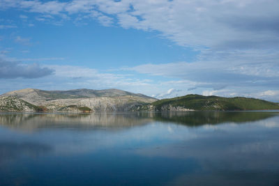 Scenic view of lake by mountain against sky