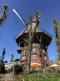 Low angle view of traditional windmill against clear blue sky