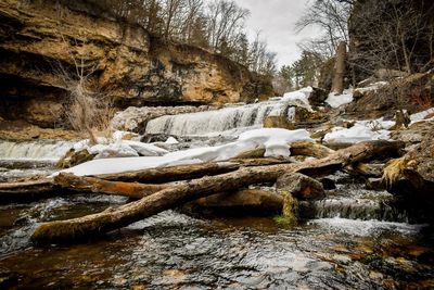 River flowing through snow in forest