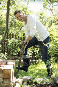 Side view portrait of happy man gardening at yard