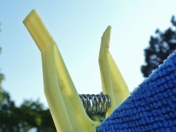 Low angle view of clothespin against clear sky on sunny day