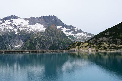 Scenic view of lake and snowcapped mountains against sky