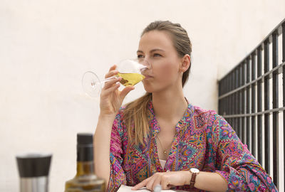 Woman on terrace tasting a glass of white wine person