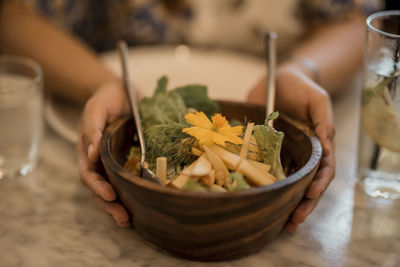 Midsection of person preparing food in bowl on table