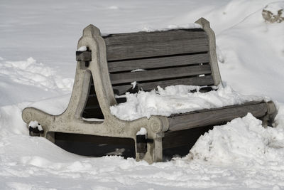 A snow covered bench after a fresh snowfall in winter.