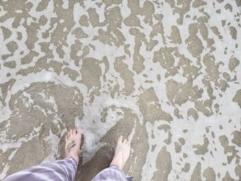 Low section of woman standing in sea