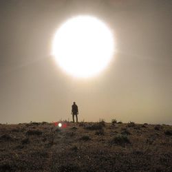 Silhouette of woman standing on field