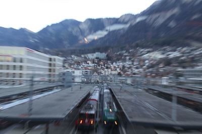 Blurred motion of cars on illuminated mountain against sky