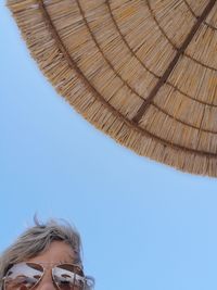 Low angle view portrait of girl against blue sky