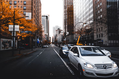 Cars on city street by buildings