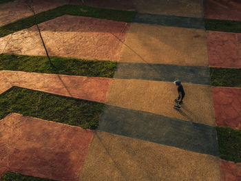 Shadow of boy playing rollerblade with nice pattern shot from above by drone