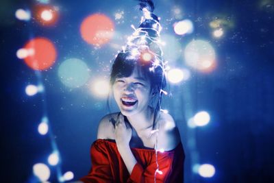 Christmas portrait of a beautiful smiling girl with christmas tree hairstyles and lights 