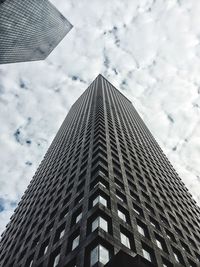 Low angle view of modern building against cloudy sky