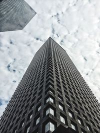 Low angle view of modern building against cloudy sky