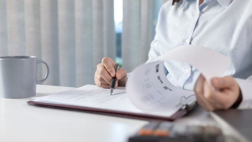 Midsection of woman working at table