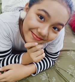 Portrait of cute baby girl lying on bed