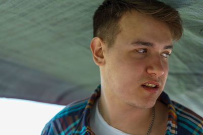 Close-up portrait of young man looking away