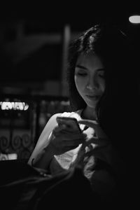 Young woman using mobile phone at night