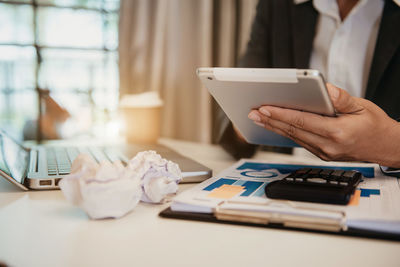 Midsection of man using laptop on table