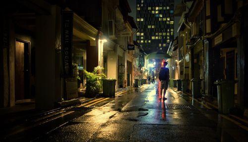 Man standing on illuminated street at night