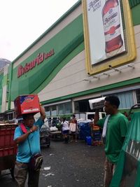 Rear view of people standing by city