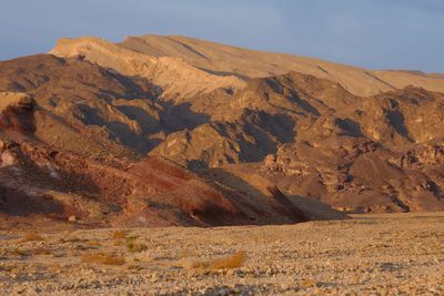 Scenic view of arid landscape against sky at sunrise 