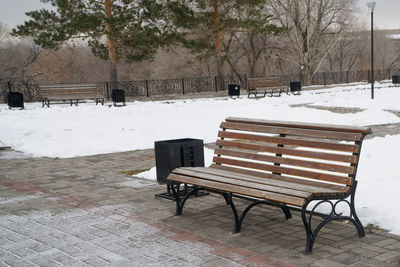 Empty bench in park during winter