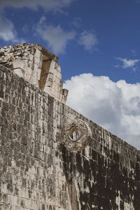 Low angle view of old building against cloudy sky