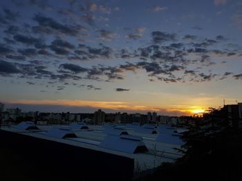 High angle view of silhouette buildings against sky during sunset