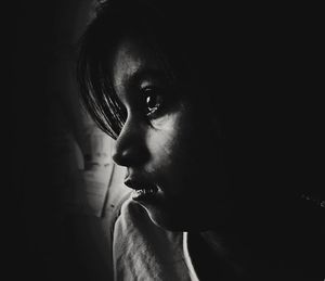 Close-up portrait of young woman in darkroom