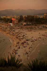 High angle view of people at beach against sky during sunset