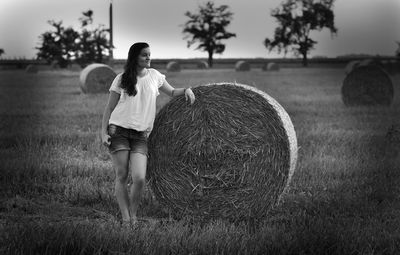 Full length of woman standing by hay