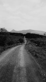 Empty road along landscape and against sky