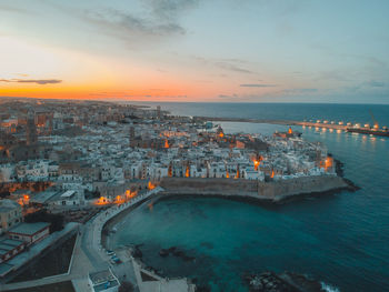 High angle view of city by sea against sky