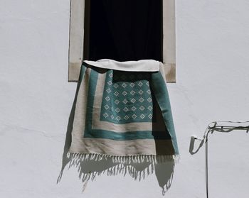 Portuguese carpete hanging on a window 