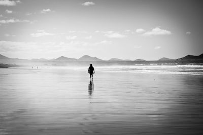 Rear view full length of man walking at beach