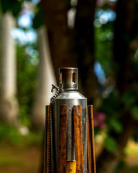 Close-up of old rusty bottle against blurred background
