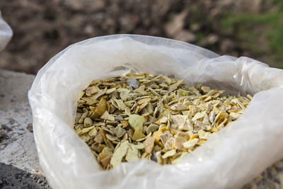 Close-up of dried food in plastic bag on retaining wall