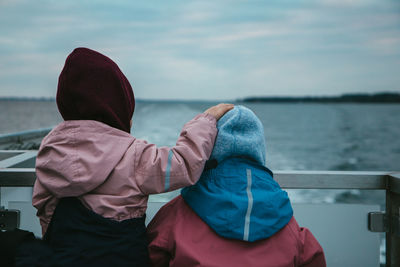 Two children watching the sea at the back of a ferryboat