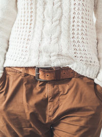 Woman in cable-knit sweater with pattern and brown chinos trousers with leather belt.casual clothes. 