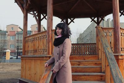 Portrait of woman standing against building