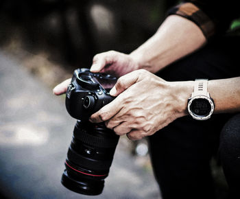 Midsection of woman holding camera