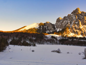 Scenic view of snow covered mountains against clear sky